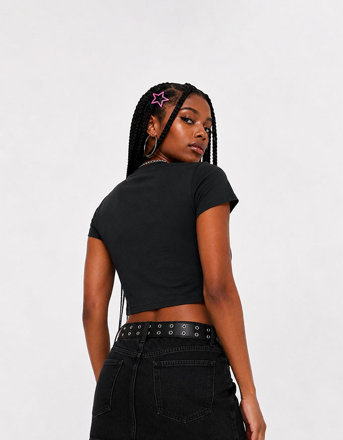 Female model wearing GUILTY PARTY black cropped baby tee with blue front graphic print