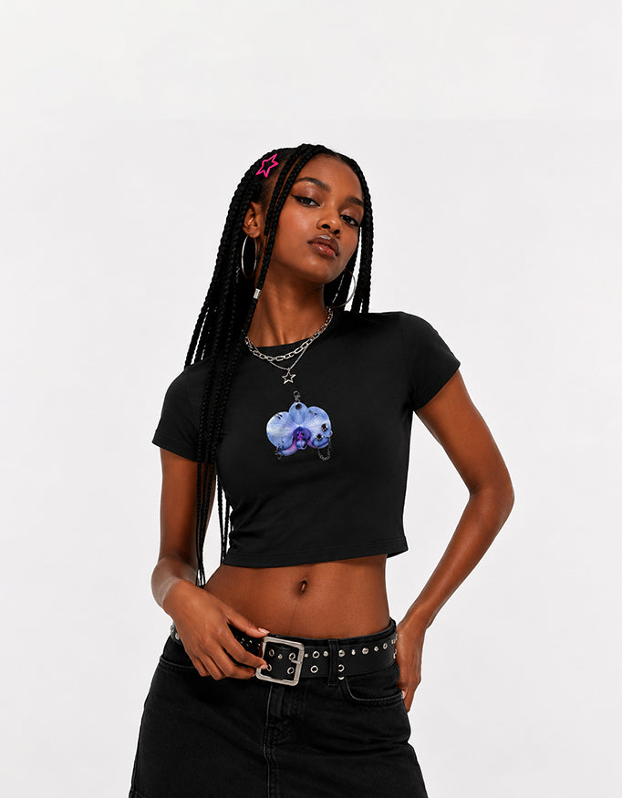 Female model wearing GUILTY PARTY black cropped baby tee with blue front graphic print