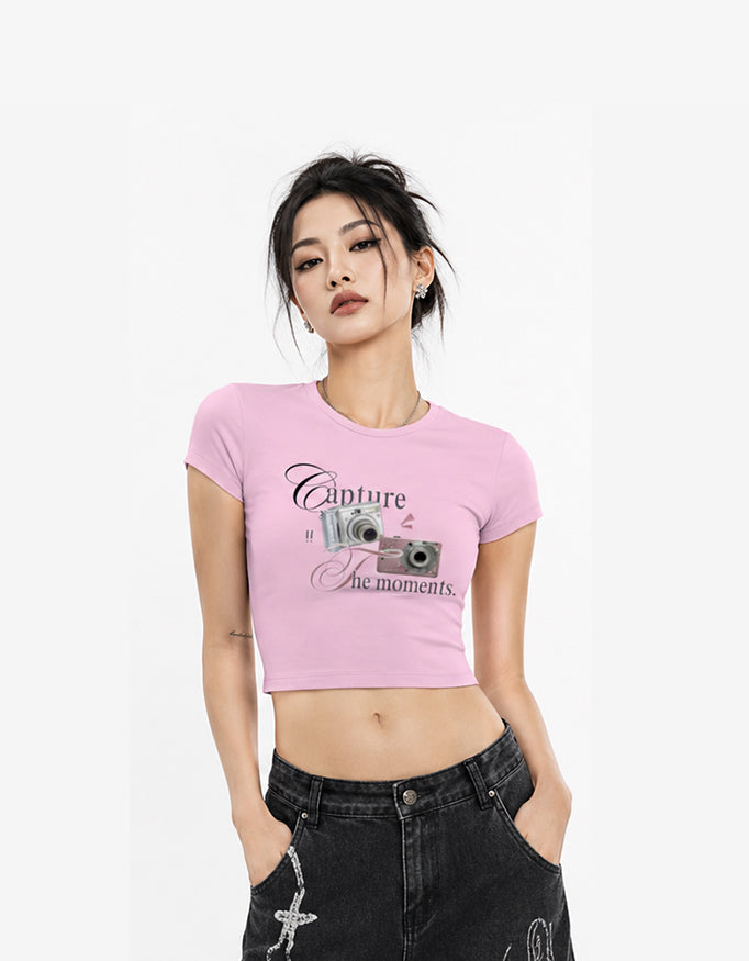 Female model wearing GUILTY PARTY white cropped baby tee with vintage camera Capture The Moments graphic print