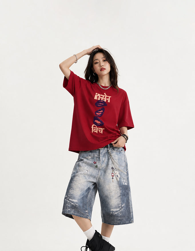 Female model wearing GUILTY PARTY red oversized Insane B!tch graphic t-shirt with abstract Hindi typography and lip print
