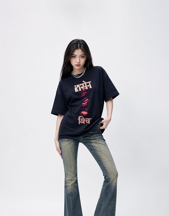 Female model wearing GUILTY PARTY red oversized Insane B!tch graphic t-shirt with abstract Hindi typography and lip print