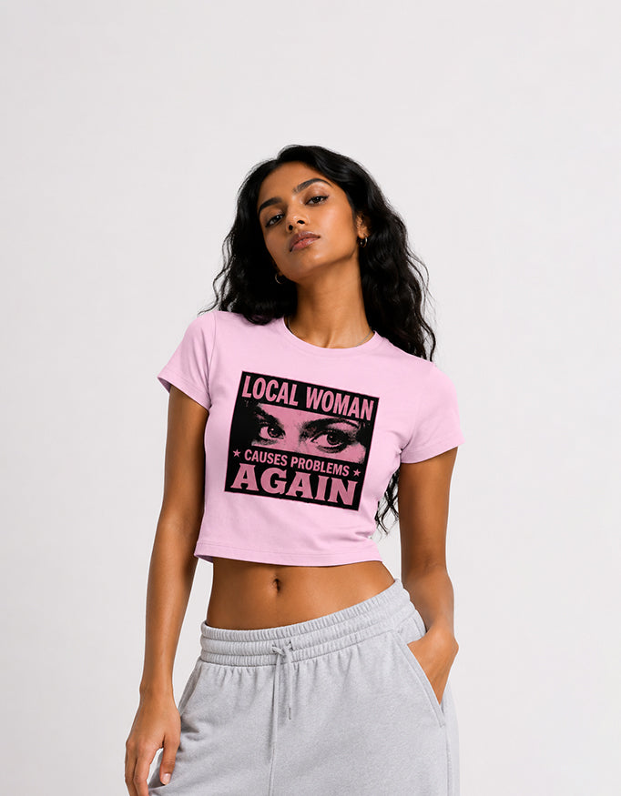 Female model wearing GUILTY PARTY white cropped baby tee with Local Woman pink graphic print
