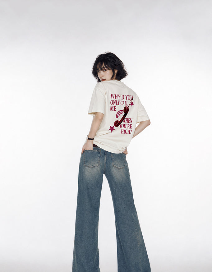 Back view of GUILTY PARTY beige oversized tee with red phone graphic and statement typography why'd you only call me when you're high?