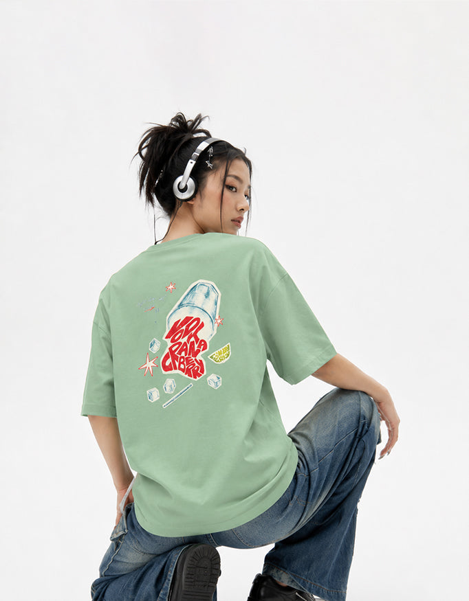 Back view of GUILTY PARTY green oversized tee with colorful graphic back print in studio shoot saying vodka cranberry