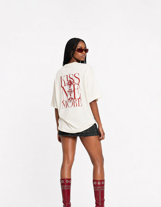 Back view of GUILTY PARTY off white oversized tee with bold red Kiss Me More graphic print